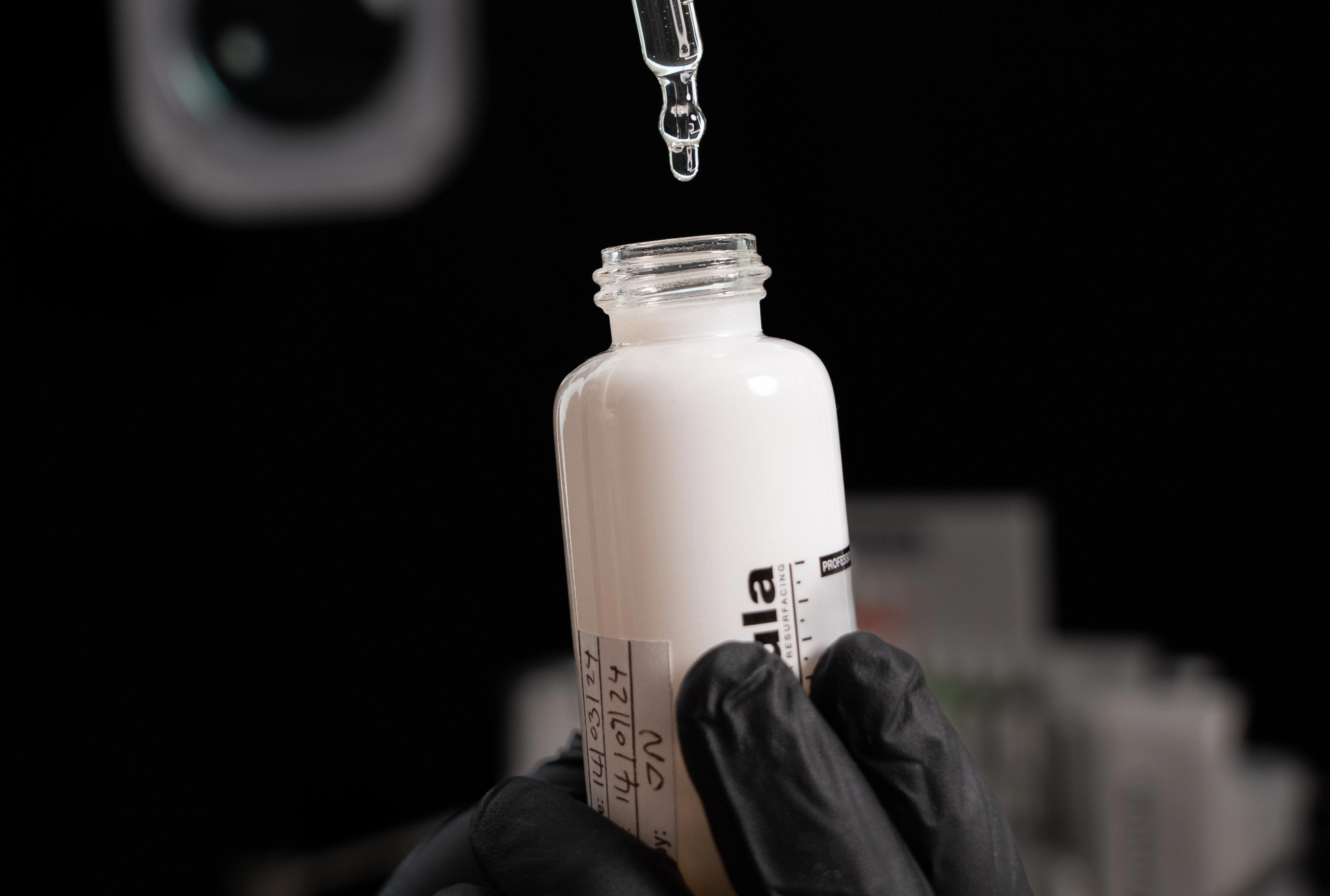 a doctor holding a pipette and a bottle